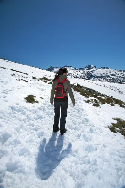 Mulher andando na montanha de neve — Fotografia de Stock
