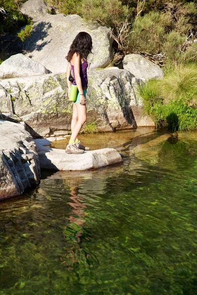 Feminino em um rio de observação de rocha — Fotografia de Stock