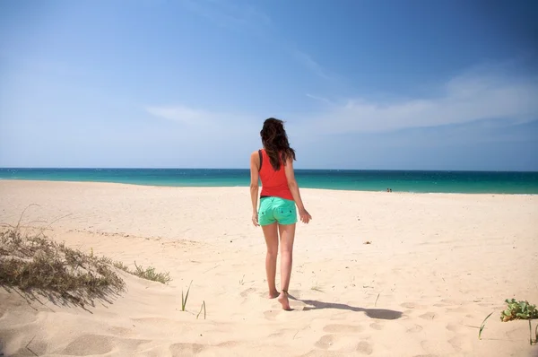 棕色头发的女人走在沙滩上 — 图库照片