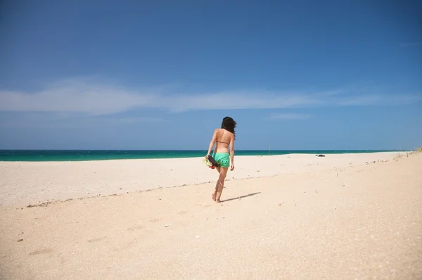 Zelené kraťasy žena chůzi na písku — Stock fotografie