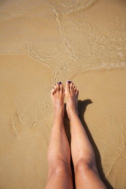 Legs in ocean at Conil beach clipart