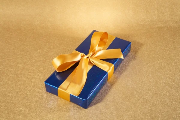 Голубая подарочная коробка с золотым бантом — стоковое фото
