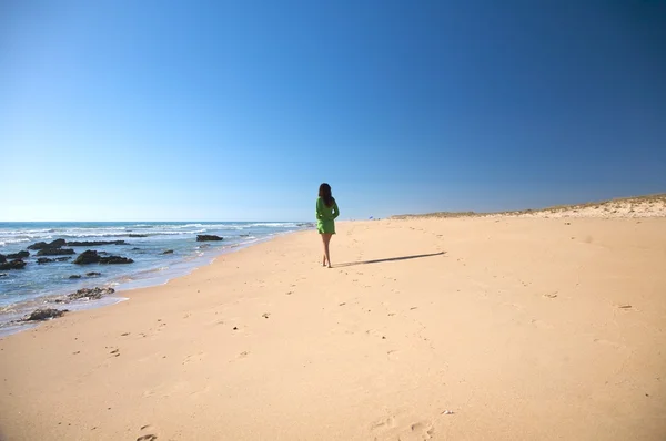 Groene jurk vrouw aan het strand — Stockfoto