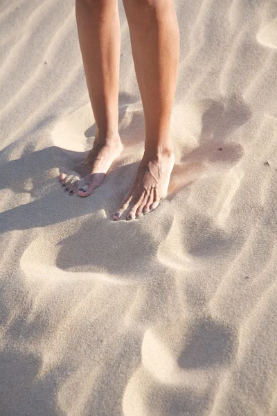 Kvinna ben på sandstrand — Stockfoto