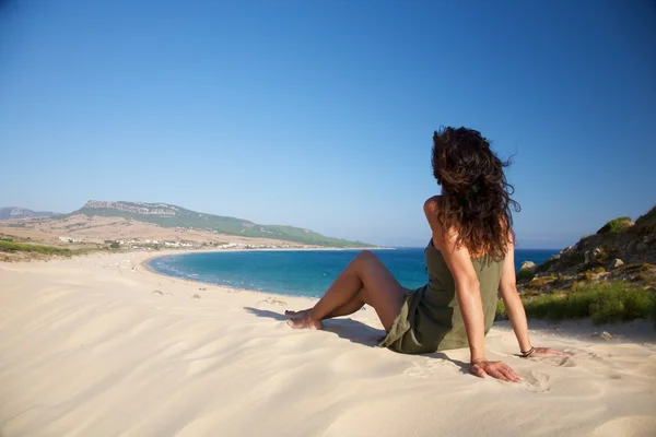 Frau sitzt am Strand von Bolonia — Stockfoto