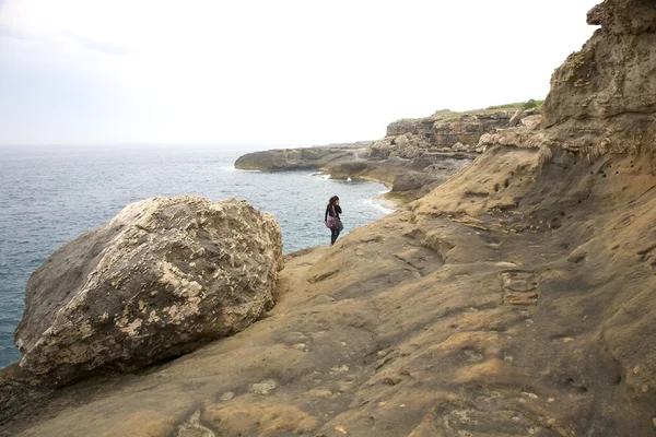Женщина ходит по скальному рифу — стоковое фото