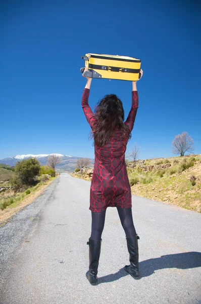 Kvinna med resväska över huvud — Stockfoto