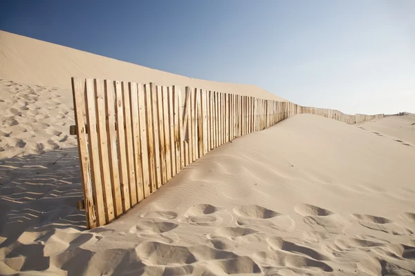 Holzzaun in großer Sanddüne — Stockfoto