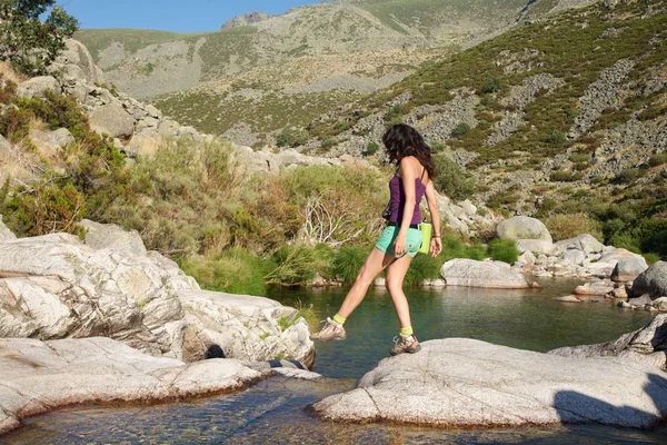 Mulher andando em uma rocha em um rio de Gredos — Fotografia de Stock