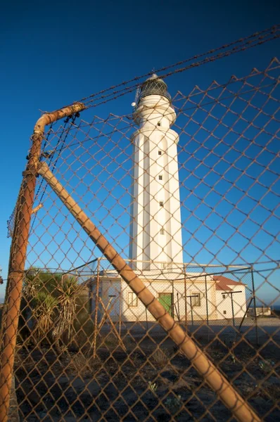 Wire fence and lighthouse — Stock Photo, Image