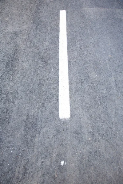 En vit linje på asfalt — Stockfoto