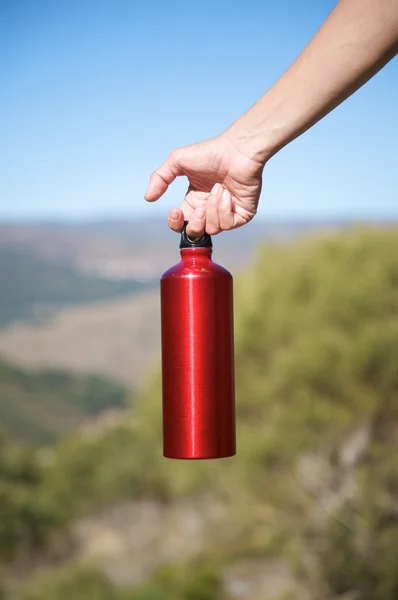 Красная бутылка в руке — стоковое фото
