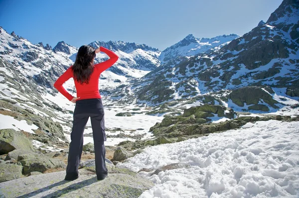 Красная женщина смотрит снежную долину — стоковое фото