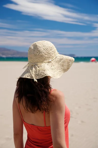 Κόκκινο γυναίκα με ψάθινο καπέλο στην παραλία — Φωτογραφία Αρχείου