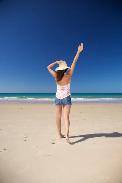 Счастливая женщина в соломенной шляпе на пляже — стоковое фото