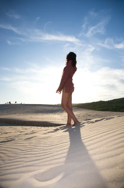 Sexy woman on dune against sun — Stock Photo, Image