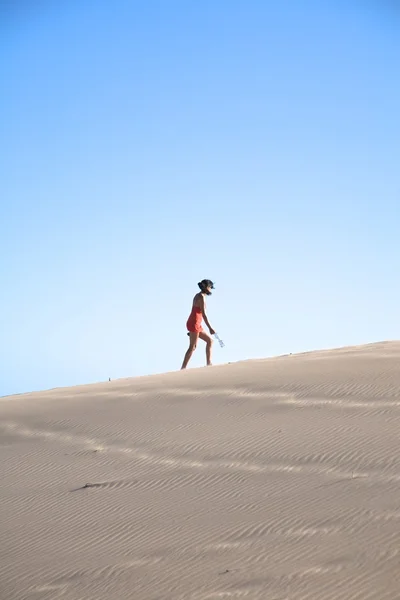 Mujer lateral en gran montaña de arena — Foto de Stock