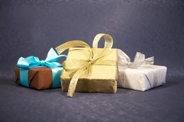 Три коробки подарков на темно-синем фоне — стоковое фото
