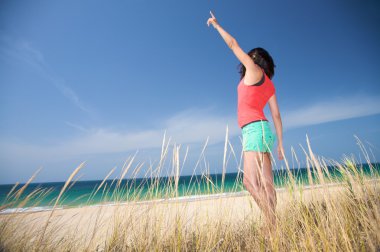 Red and green woman comes to the beach clipart