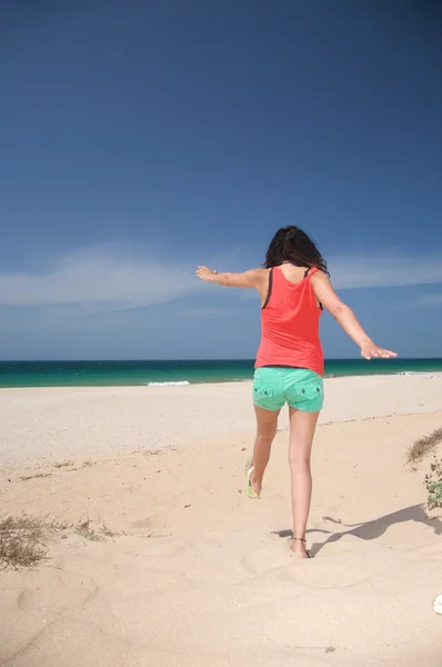 Шорты женщина прыгает по песку — стоковое фото