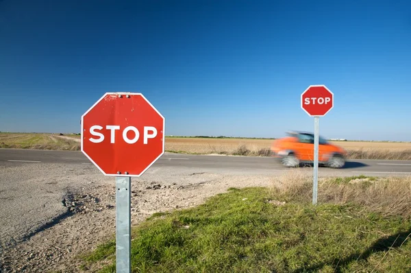 Скоростной автомобиль через знаки остановки — стоковое фото
