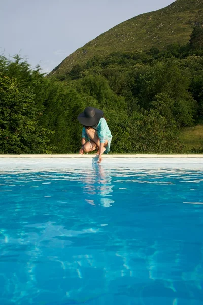 Testing water on swimming pool border — Stock Photo, Image