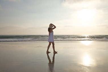 Walking with hat against sun clipart