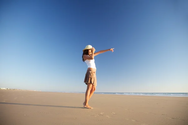 Puntando donna con cappello in spiaggia — Foto Stock