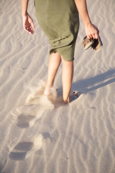 Woman walking and footprints — Stockfoto