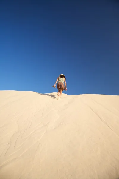Woman walking up the dune — Stock Photo, Image