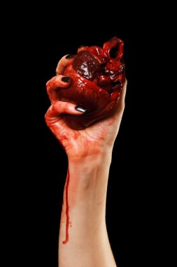 Human heart in hand isolated on black