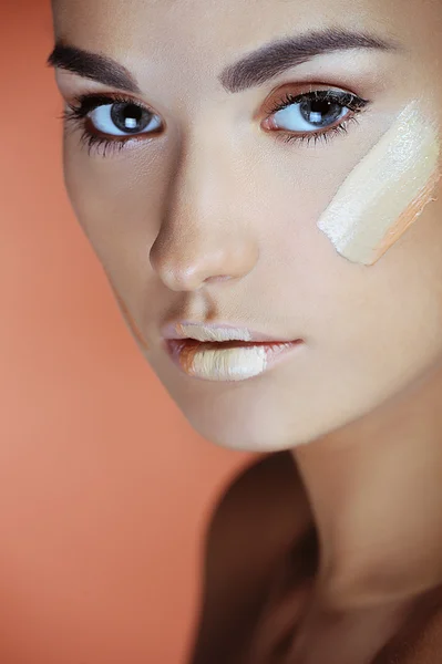 Hermosas mujeres aplicando crema de maquillaje femenino — Foto de Stock