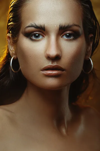 Молодая красивая девушка с бронзовым загаром и золотым макияжем — стоковое фото