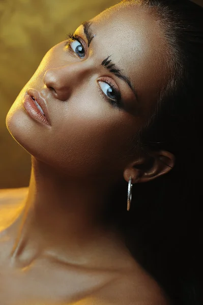 Young beautiful girl with a bronze tan and gold makeup — Stock Photo, Image