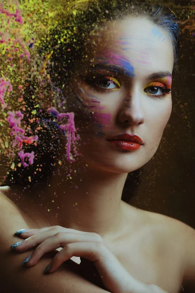 Beautiful woman in color paint behind the painted glass — Stock Photo, Image