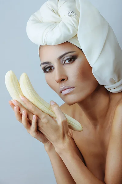 Hermosa mujer en bufanda blanca con plátano en las manos — Foto de Stock
