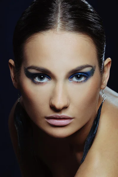 Junge schöne Frau mit blauem Make-up in langen Ohrringen — Stockfoto