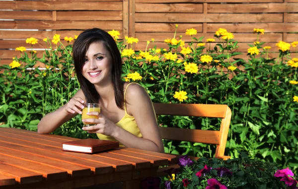 Hezká dívka s knihou v zahradě — Stock fotografie