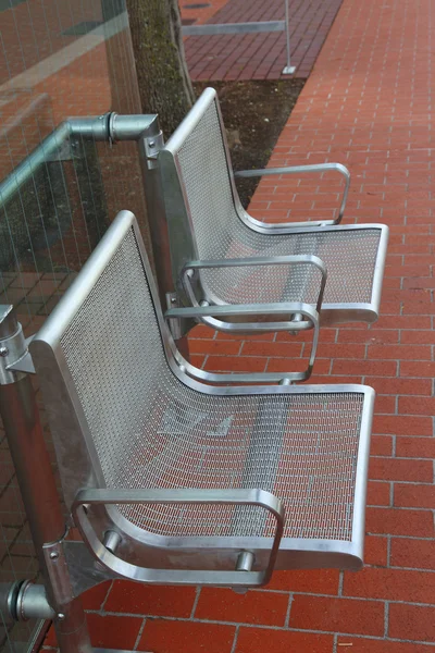 Stainless steel chairs at a bus stop. — Stock Photo, Image