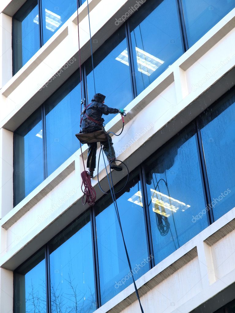 Pressure washing a building.