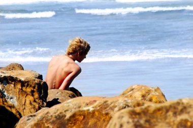 plajda kayalar üzerinde çocuk