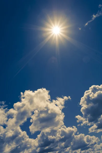 Soare strălucitor pe cer albastru cu nori pufoși — Fotografie, imagine de stoc