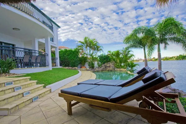 Liegestühle am Pool in der Villa am Wasser — Stockfoto