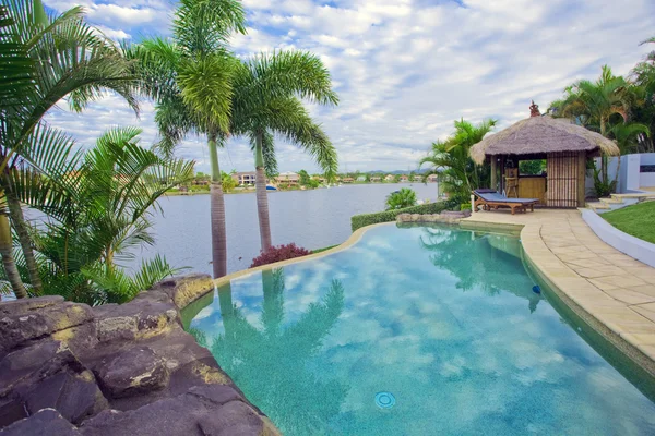 Waterkant herenhuis met zwembad en bali hut met uitzicht op de gracht — Stockfoto