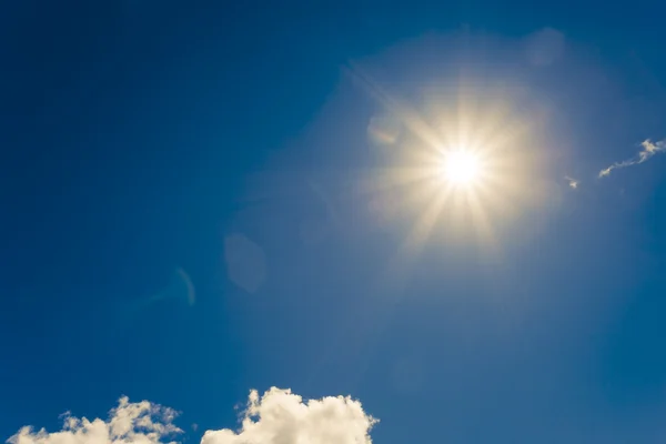 Strahlende Sonne am blauen Himmel mit Wolken — Stockfoto
