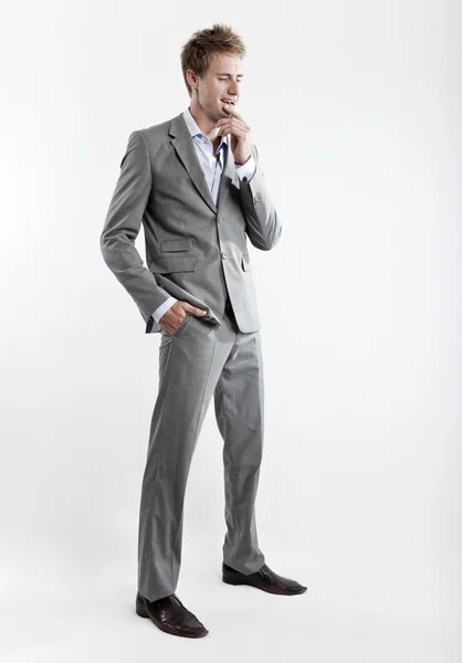 Homem de negócios em terno cinza no fundo branco no estúdio — Fotografia de Stock