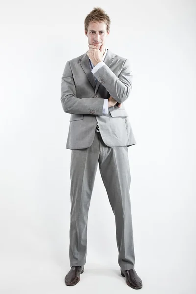 Obchodní muž v šedém oblek na bílém pozadí v studio — Stock fotografie