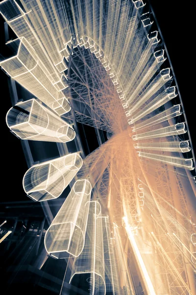 stock image Ferris Wheel in motion glowing at night