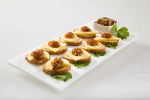 Bagel crisps with chutney and cheese — Stock Photo, Image