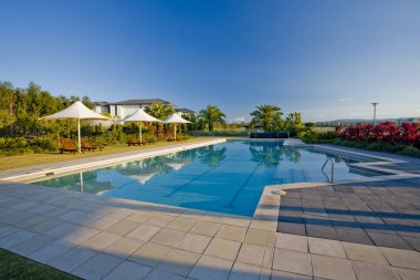 Deck chairs and parasols by the pool clipart